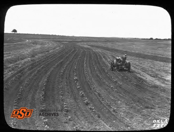 Two Men with Tractor Planting Row Crops Along Contours 